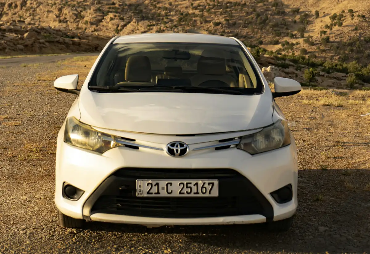 A white toyota car parks facing the camera.